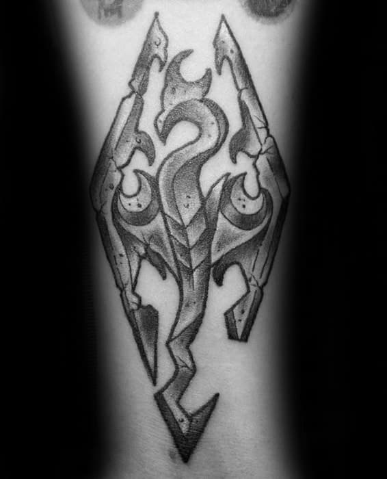 A black and white tattoo of a stylized Skyrim dragon emblem with angular shapes