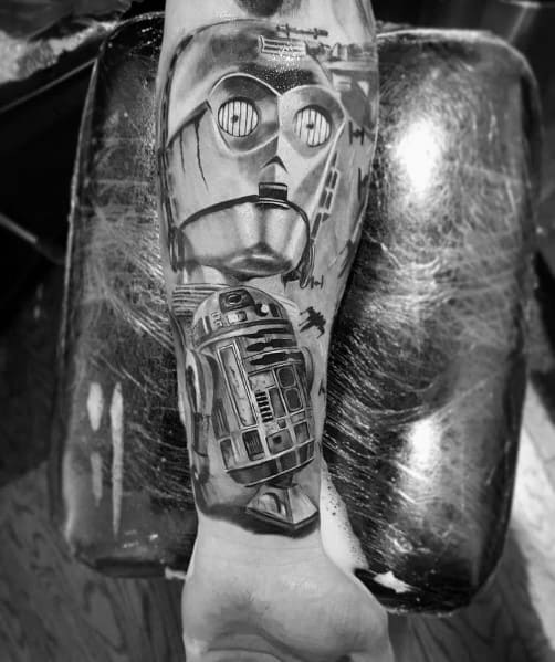 Black and grey Star Wars tattoo featuring C-3PO and R2-D2 with TIE Fighters in the background, creating a detailed cinematic design.