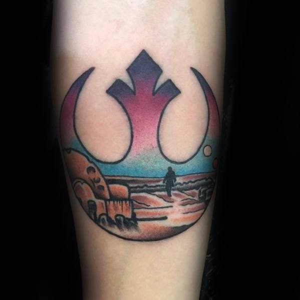 Rebel Alliance tattoo on the forearm, featuring a desert landscape and a lone figure walking.
