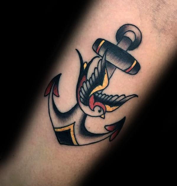 Traditional anchor tattoo with a swallow, bold black outlines, red and yellow accents, symbolizing safe travels, hope, and stability.