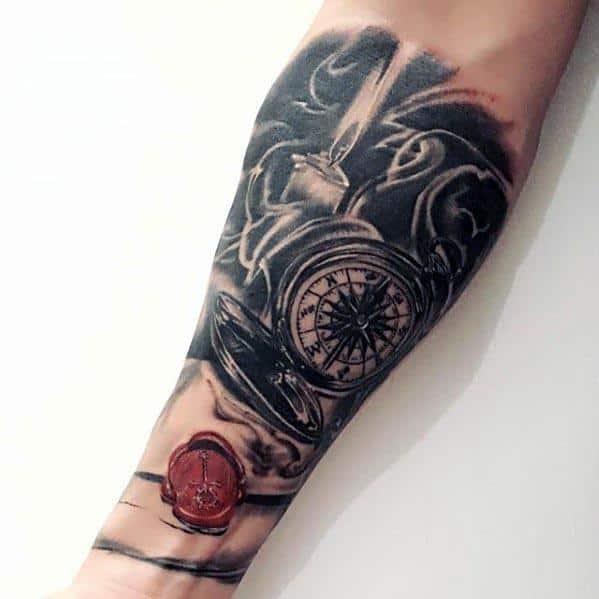 Forearm tattoo featuring a compass, a candle, an envelope, and a wax seal on a dark background