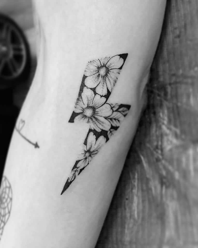 Tattoo of a lightning bolt filled with detailed flowers