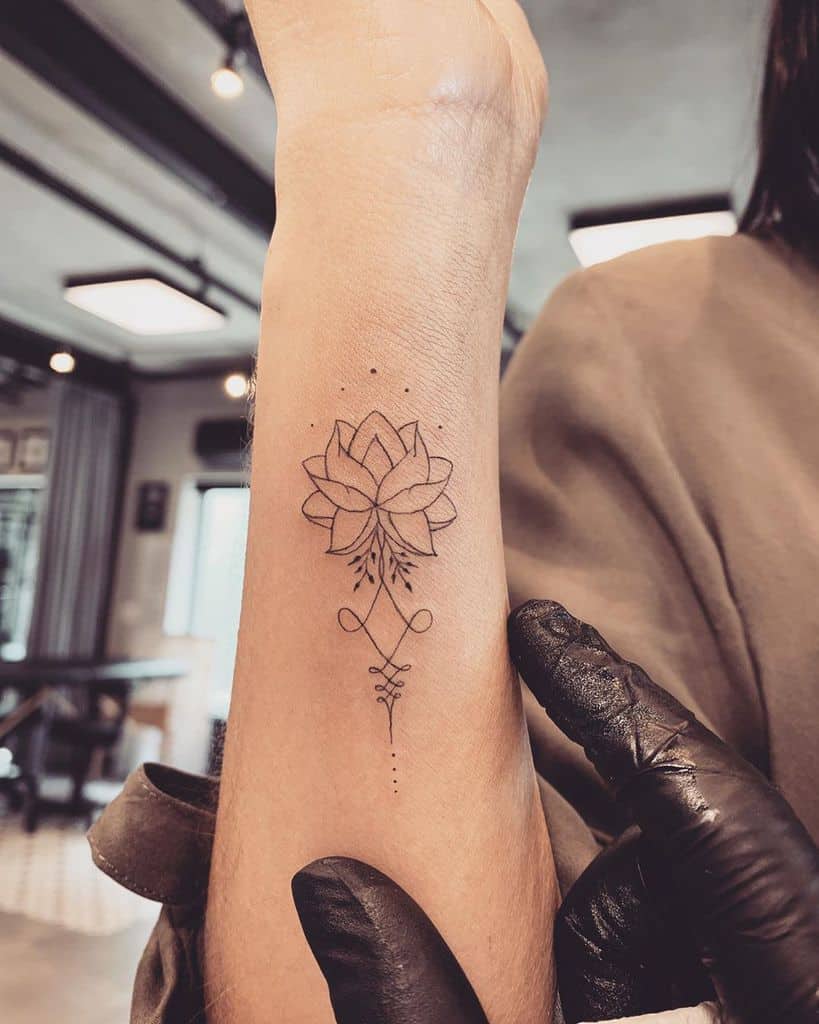 Unalome tattoo with a lotus on the wrist, symbolizing spiritual growth, enlightenment, and the journey toward inner peace and self-discovery.