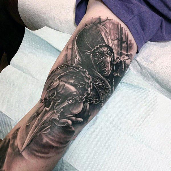 Black and grey tattoo of a hooded warrior with a masked face, gripping chains and a dagger, featuring intense shading and fine details