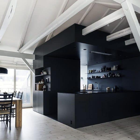 Minimalist black kitchen with open shelves, matte cabinets, and high ceilings.