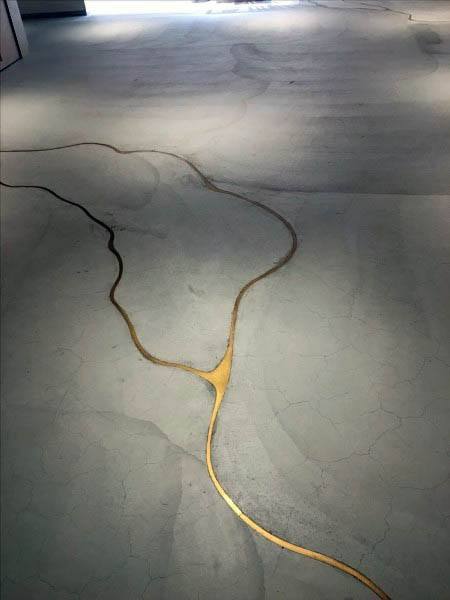 Golden cracks resembling tree branches or rivers elegantly decorate the concrete floor