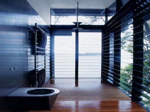 Modern shower with large windows and sleek dark design overlooking a scenic view