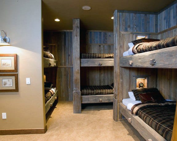 Rustic wooden bunk beds in a cozy room with earthy tones and soft lighting.