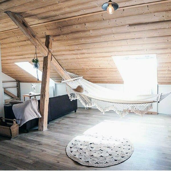 Cozy indoor hammock in a rustic attic with wooden beams and natural light.