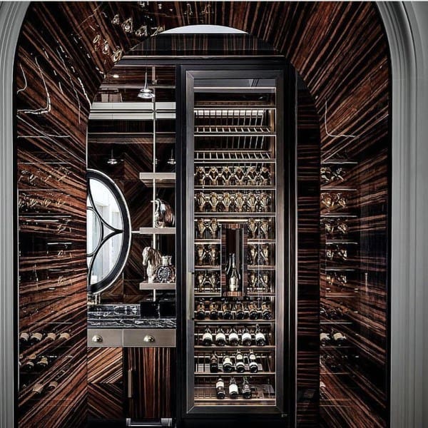 Luxurious wine cellar with dark wood, mirror accents, and a circular window reflecting an elegant wine interior design