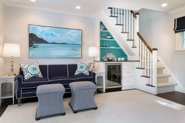Carpeted staircase with built-in shelving and white railing in a bright living room with coastal decor.