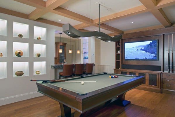 Billiard room with wood pool table wall decor bar area and mounted TV for entertainment.