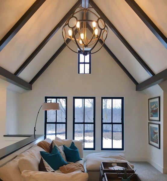 Elegant lounge with vaulted ceiling, modern chandelier, and sectional sofa.
