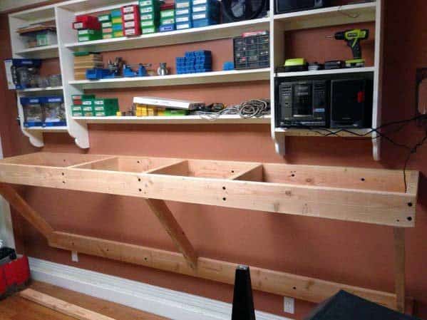 Sturdy unfinished wooden reloading bench frame with overhead shelves for organized tools, ammo boxes, and components