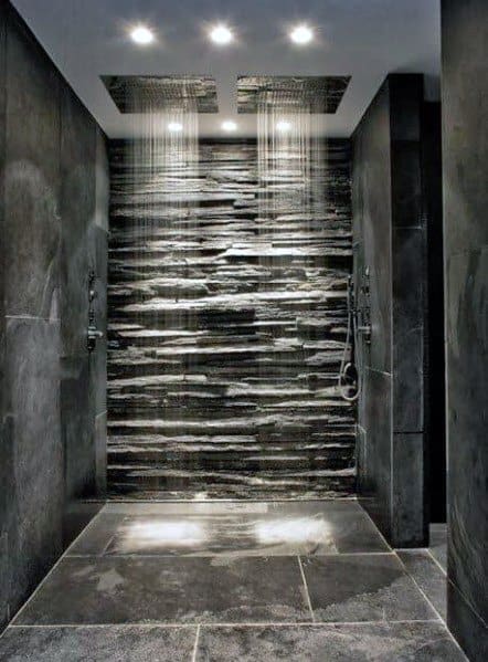 Modern double shower with stone wall, rainfall showerheads, and sleek floor design