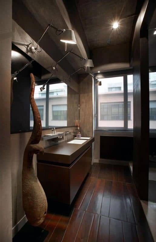Industrial-style bathroom featuring dark wood flooring, concrete walls, large windows, modern vanity, and track lighting.