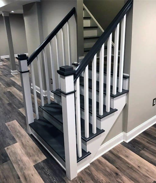 White and black staircase with vertical railing and dark wood steps in a modern basement.