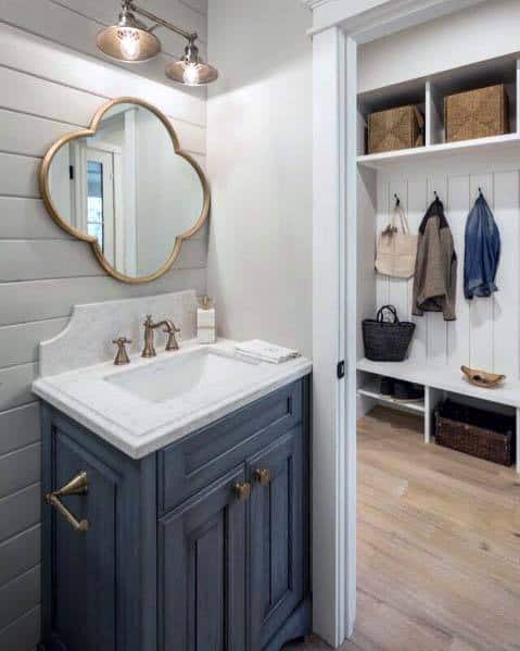 small bathroom with blue cabinet vanity and shiplap walls