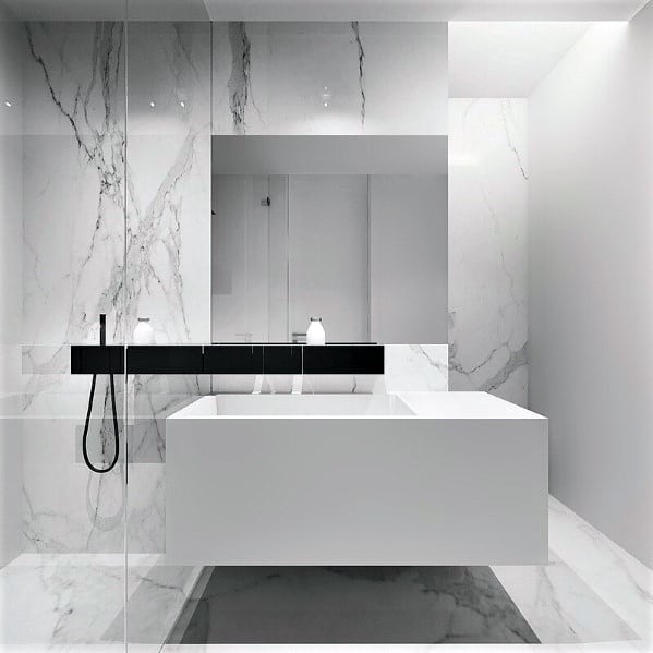 White modern bathroom with marble walls, glass shower, and sleek fixtures