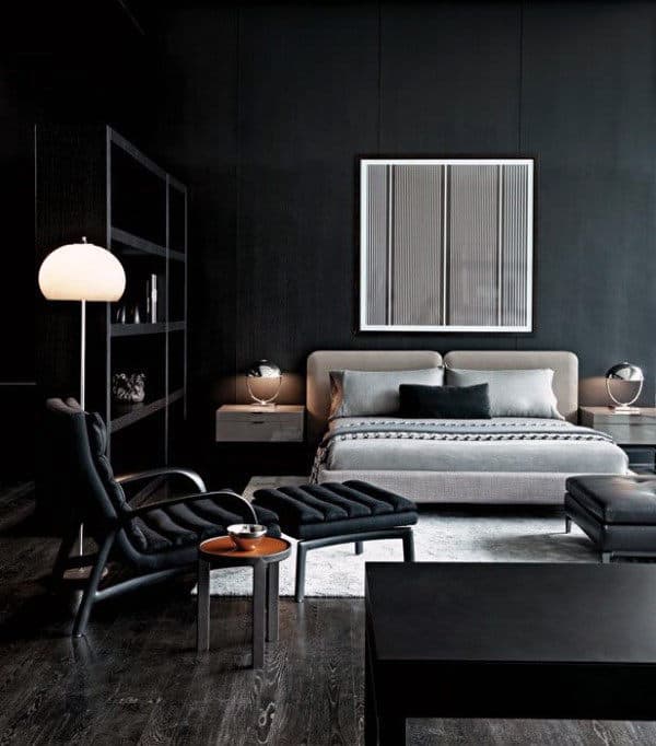dark modern bedroom with gray platform bed and eames chair 