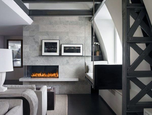 Modern fireplace with gray stone wall, industrial accents, and cozy built-in window seating.