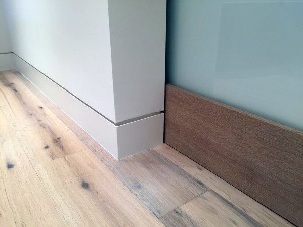 Modern baseboard with clean lines, light wood flooring, and glass panel detail.