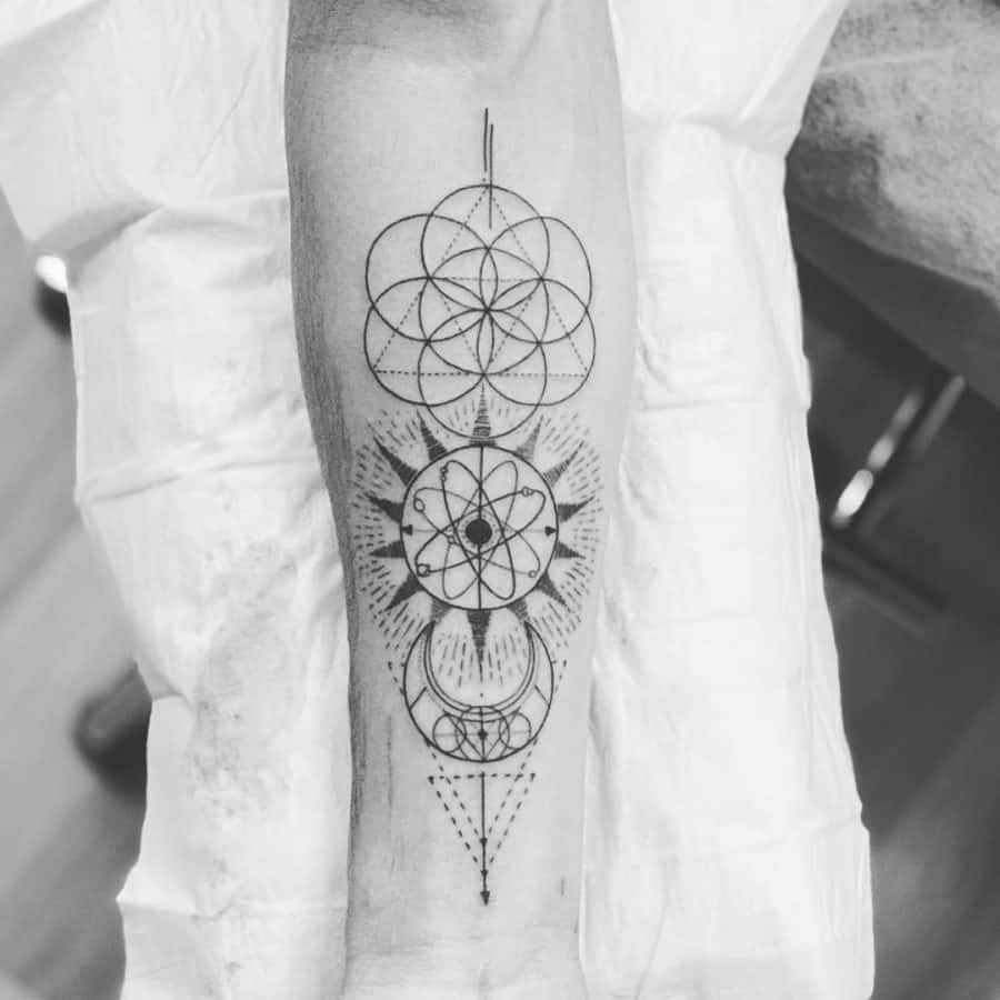 Geometric black ink tattoo featuring interconnected sacred geometry, a sun, a crescent moon, and intricate dotwork for a celestial design.