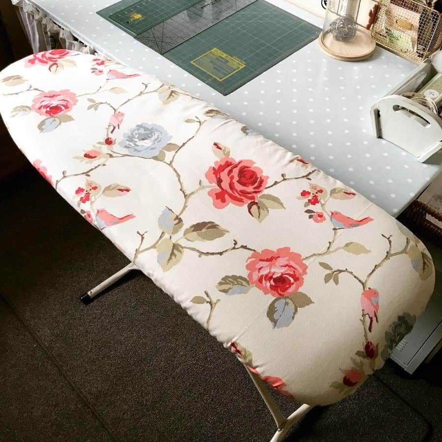 Floral ironing board setup in a sewing room with polka-dot workspace and organized tools for efficient crafting