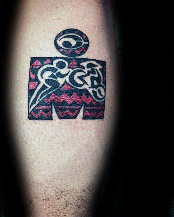 Tribal-style Ironman logo tattoo with bold red and black zigzag patterns and stylized swim, bike, and run figures inside the shape.