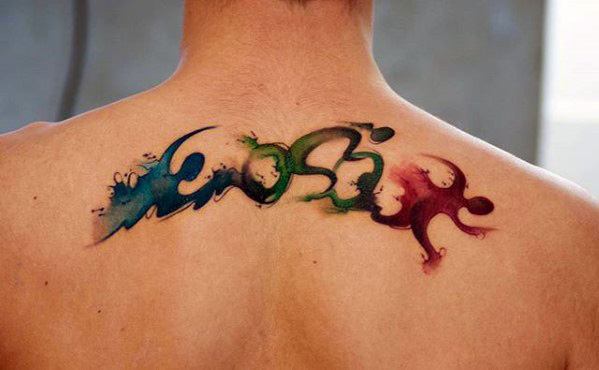 Triathlon tattoo featuring watercolor-style waves and fluid shapes representing swimming, cycling, and running across the upper back.