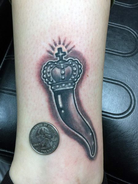 Black and grey Italian horn tattoo with a crowned design, symbolizing luck, strength, and protection.