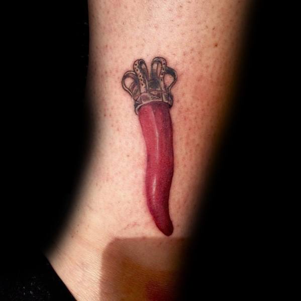 Red Italian horn tattoo with a detailed crown, symbolizing luck, protection, and cultural heritage.