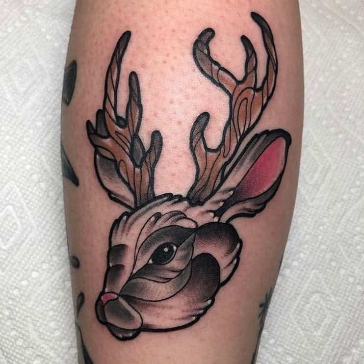 Vibrant tattoo of a rabbit with intricately designed antlers, featuring bold outlines and shading