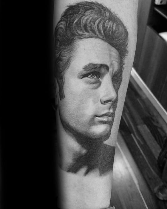 Realistic black and grey forearm tattoo of James Dean gazing upward, capturing his iconic brooding expression.