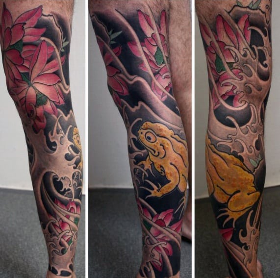 Japanese-style full-leg tattoo featuring a golden frog surrounded by red lotus flowers and swirling black waves, symbolizing luck, prosperity, and nature's flow.