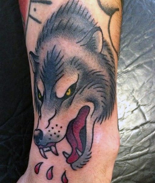 Tattoo of a fierce wolf, its mouth open in a menacing snarl, with red drops dripping down the skin