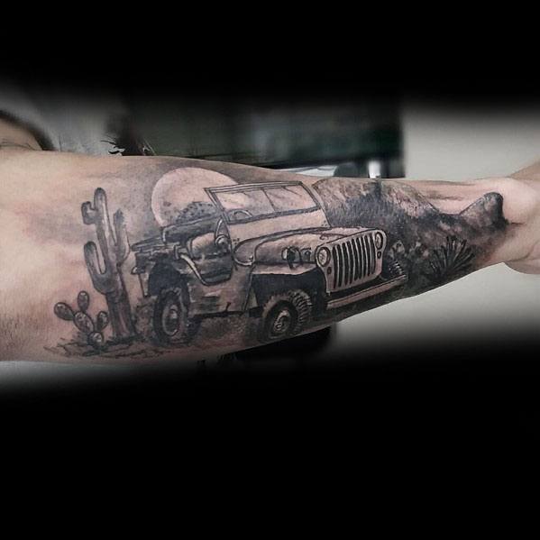 Black and grey tattoo of a classic Jeep driving through a desert landscape with cacti, mountains, and a full moon in the background.