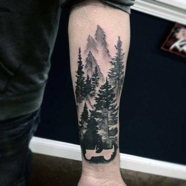 Black and grey tattoo of a Jeep silhouette integrated into a dense forest and mountain landscape, creating a nature-inspired adventure design.