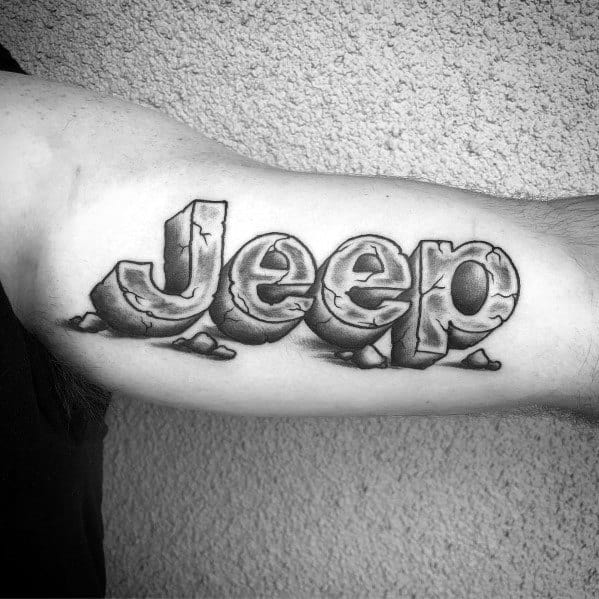 Black and grey tattoo of the word "Jeep" in a bold, stone-like 3D design with cracks and shading for a rugged, off-road look.