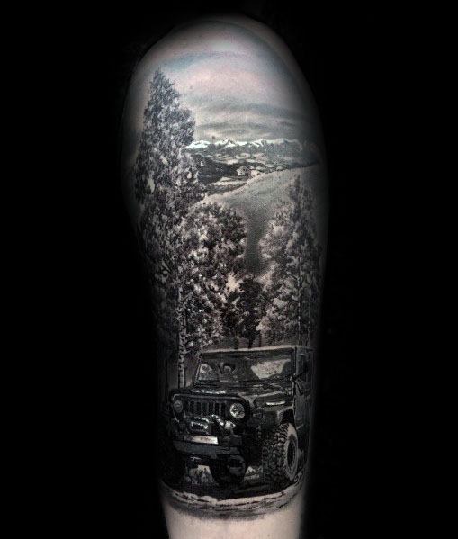 Hyper-realistic black and grey tattoo of a Jeep driving through a dense forest with towering trees and a scenic mountain landscape in the background.