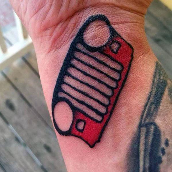 Bold Jeep grille tattoo in black and red ink, placed on the wrist, featuring the iconic seven-slot design with headlight cutouts.