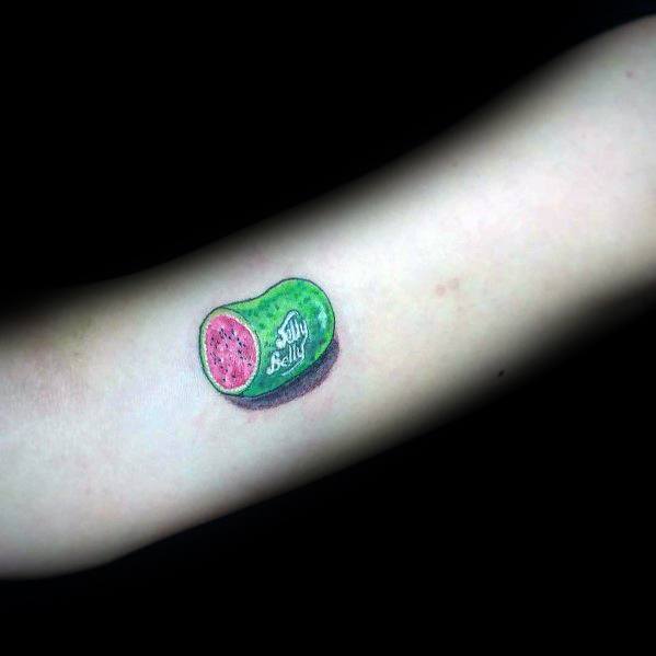 Realistic Jelly Belly watermelon candy tattoo with detailed shading and highlights, creating a small but vibrant 3D effect on the skin.