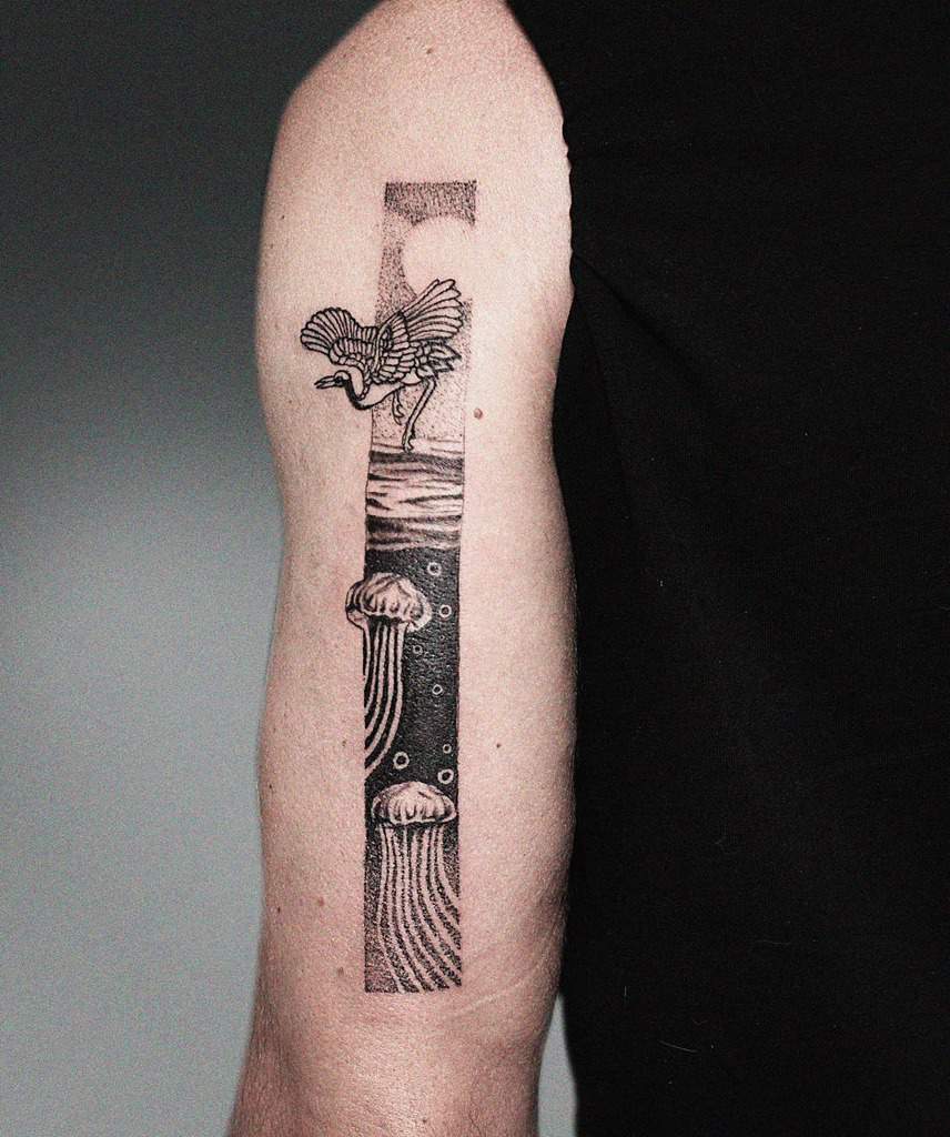 Minimalist ocean-themed tattoo featuring a heron above water and jellyfish floating in the depths within a vertical frame