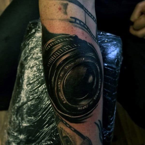 Jet Black Camera Lens Tattoo Male Forearms