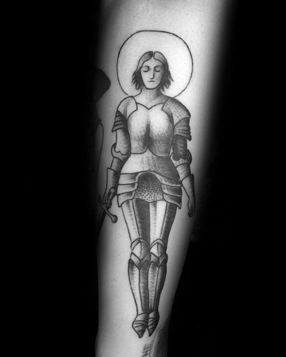 Minimalist blackwork Joan of Arc tattoo with full armor, closed eyes, halo, and downward-pointed sword, evoking peace and strength.
