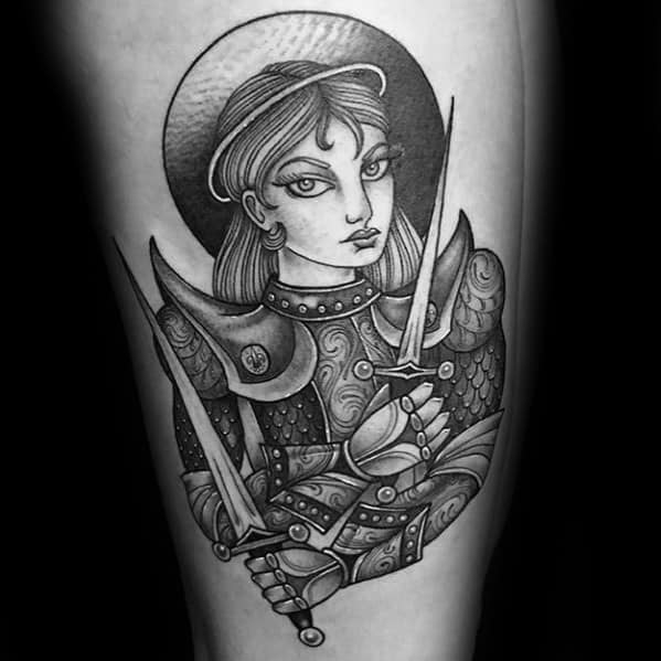 Black and grey Joan of Arc tattoo with detailed armor, bold eyes, and two swords, blending illustrative and ornamental styles.