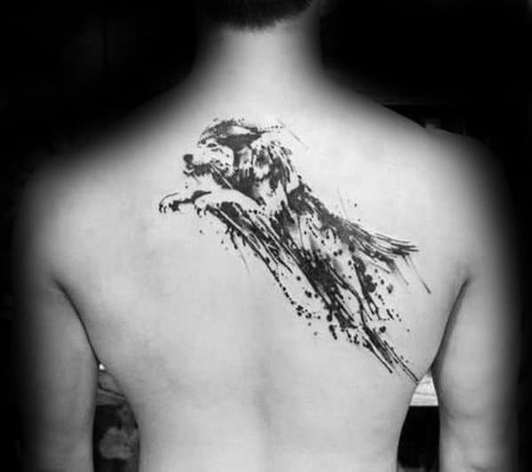 Dynamic black ink wolf tattoo on upper back featuring a leaping pose with bold brush strokes and splatter effect for motion and intensity.