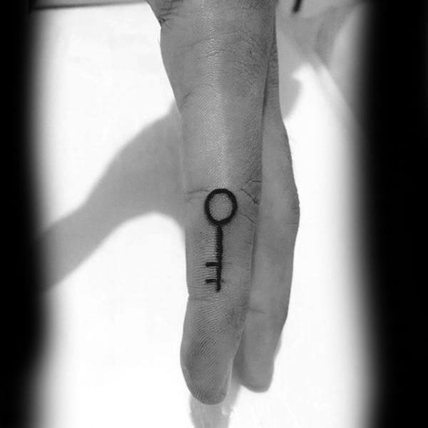 Tattoo of a key on the side of a finger