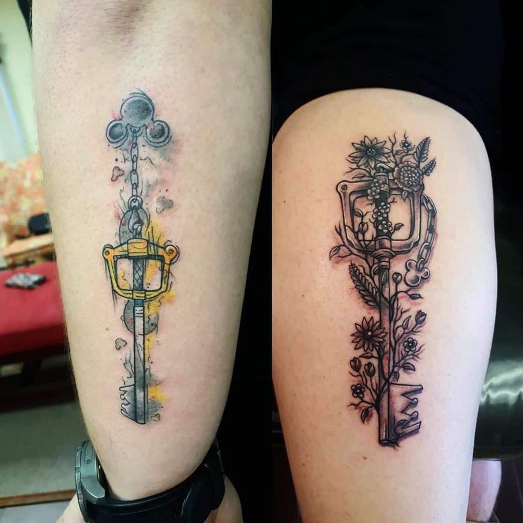 Two Kingdom Hearts Keyblade tattoos—one with a watercolor effect and glowing accents, the other with intricate floral details in black ink.
