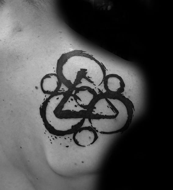 Coheed and Cambria Keywork tattoo on the upper back with bold black ink and splattered detailing for a raw, artistic finish.